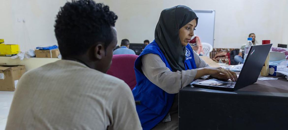 إحدى موظفات المنظمة الدولية للهجرة تسجل مهاجرا إثيوبياً في مأرب باليمن، قبل السفر إلى أديس أبابا.