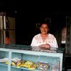 Una mujer en su casa y tienda en Buga, Colombia, donde trabaja por temporadas para la alianza de productores de maracuyá.