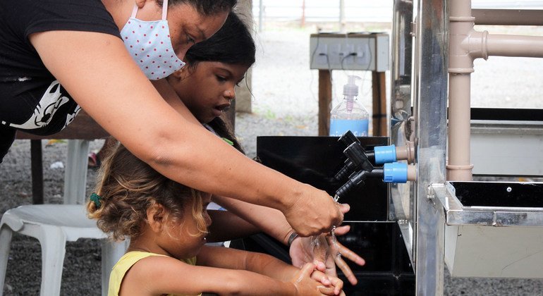 Em Boa Vista, no Brasil, crianças lavam as mãos em estação instalada com apoio da ONU.