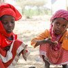 两名埃塞俄比亚女孩正在吃饭，她们是世界粮食计划署学校供餐计划的受益者。