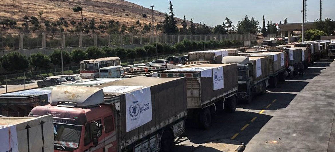 Caminhões que transportam assistência alimentar cruzam a fronteira da Turquia com a Síria