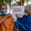 कोलम्बिया में आदिवासी समुदाय के एक सदस्य को कोविड-19 वैक्सीन का टीका लगाए जाते हुए