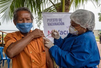 कोलम्बिया में आदिवासी समुदाय के एक सदस्य को कोविड-19 वैक्सीन का टीका लगाए जाते हुए