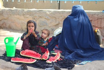 अफ़ग़ानिस्तान के लश्करगाह में लड़ाई से जान बचाकर भागी एक महिला अपनी बेटी के साथ, कन्दाहार में विस्थापितों के लिये बनाए गए शिविर में.