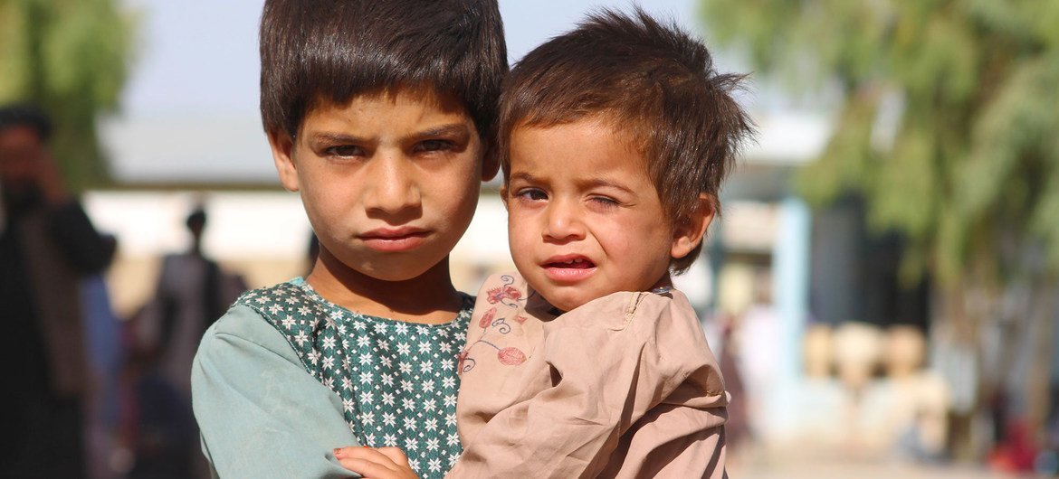 Un niño de cinco años sostiene a su hermano menor en un campo de desplazados en Kandahar, al sur de Afganistán.