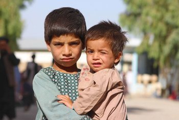 在阿富汗南部坎大哈的一个流离失所者营地，一名五岁男孩抱着他的弟弟。