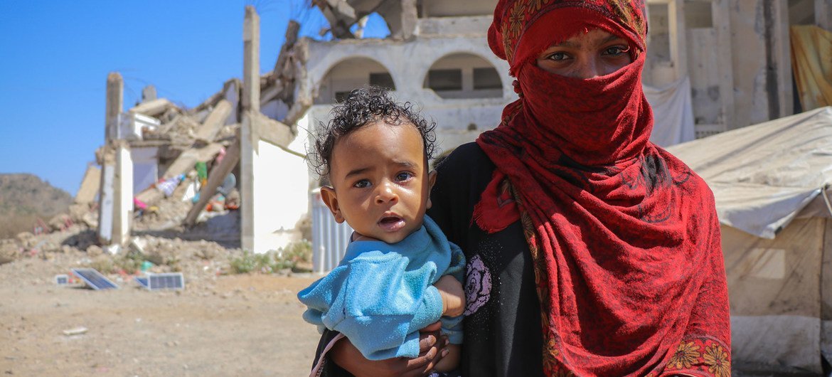 Una madre sostiene a su hijo en el campamento de desplazados internos de Al Dhale'e en el Yemen.