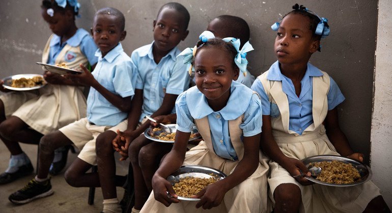 مجموعة من الاطفال في هايتي يستمتعون بالأكل الذي وزعه لهم برنامج الأغذية العالمي.