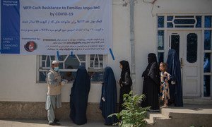 受新冠疫情影响的妇女在阿富汗喀布尔等待接受世界粮食计划署的现金援助。