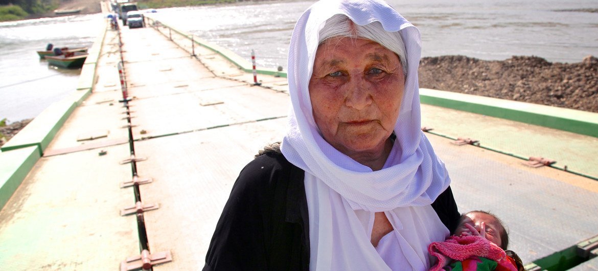 سيدة إيزيدية كبيرة في السن تحمل طفلا عمره 13 يوما تفر من سنجار وتعاود الدخول إلى العراق عبر سوريا (2020).