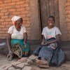 Ruth Sandrum akimsimulia mjukuu wake Yotamu Stanford mwenye umri wa miaka 14 nje ya nyumba yao huko Kasale, wilaya ya Ntcheu nchini Malawi.