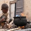 طفل يساعد في تحضير الإفطار لوالدته في النيجر.