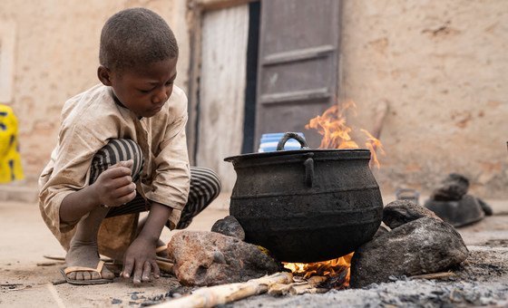 A child helps to prepare breakfast for his mother in Niger. 