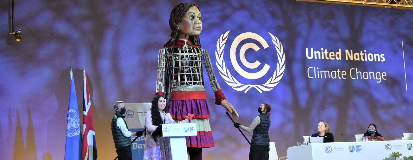 La activista samoana Brianna Fruean comparte protagonismo en la sesión plenaria de la COP26 con Little Amal, una marioneta gigante que representa a una niña refugiada siria.