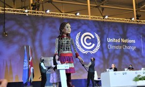 La activista samoana Brianna Fruean comparte protagonismo en la sesión plenaria de la COP26 con Little Amal, una marioneta gigante que representa a una niña refugiada siria.