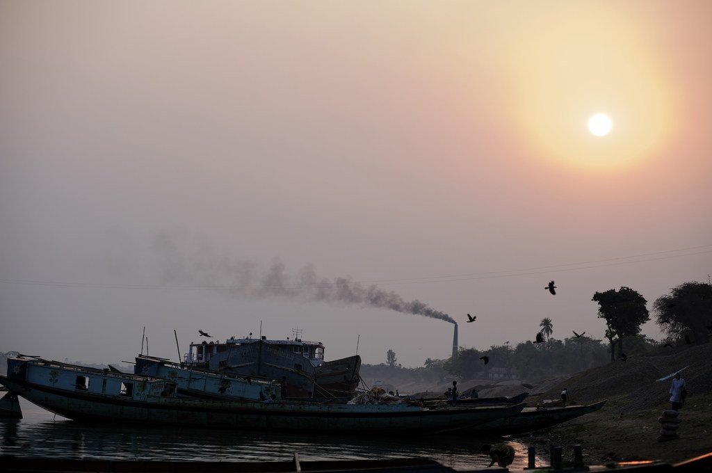 De la fumée noire s'élève d'une cheminée d'un four à briques, qui utilise le feu de charbon pour cuire les briques, dans l'est du Bangladesh. 