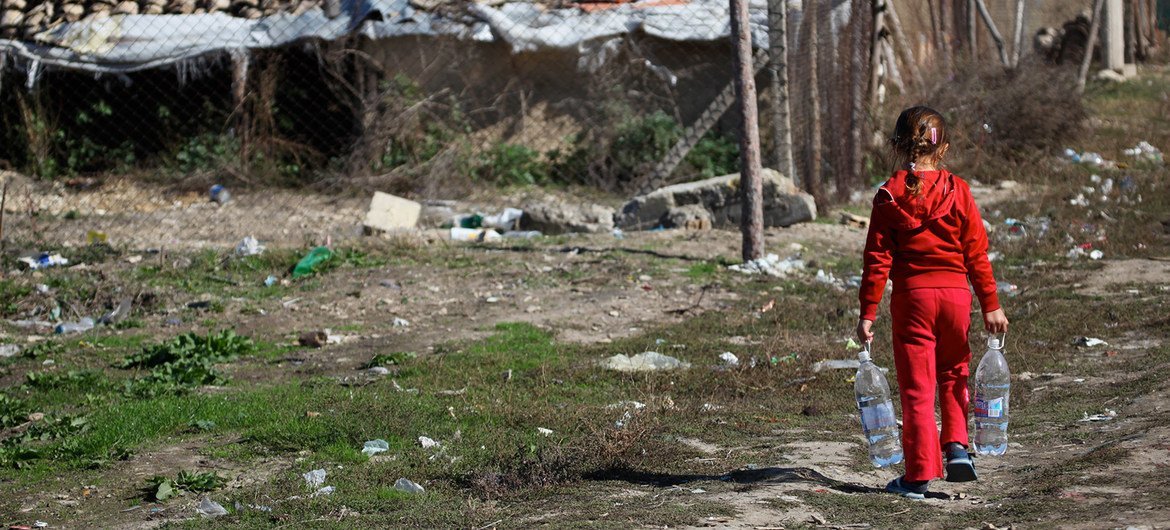 Une jeune fille transporte des bouteilles d'eau dans la communauté défavorisée où elle vit dans le nord de la Bulgarie.