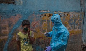 Un agent de santé sensibilise à la Covid-19 dans un bidonville de Mumbai en Inde.