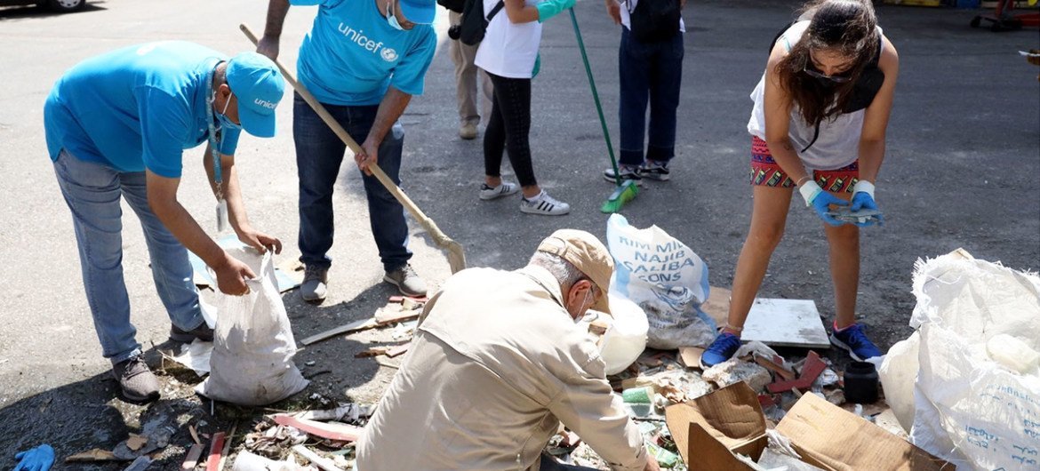 موظفون في اليونيسف ينظفون مخلفات الانفجار في شارع المدور بالكرنتينا في بيروت.