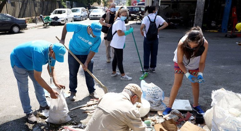 موظفون في اليونيسف ينظفون مخلفات الانفجار في شارع المدور بالكرنتينا في بيروت.