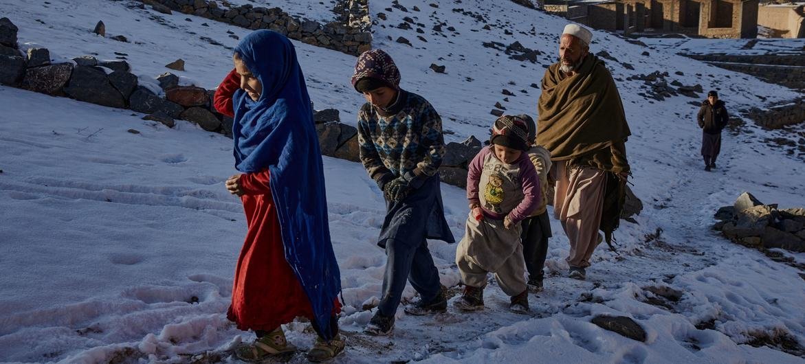 Familia desplazada recolectando agua durante el invierno en Kabul, Afganistán.