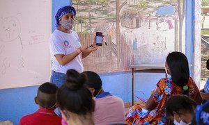 Una maestra explica cómo usar la aplicación para acceder al material educativo en los dispositivos móviles. La Guajira, Colombia