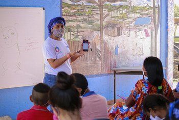 Una maestra explica cómo usar la aplicación para acceder al material educativo en los dispositivos móviles. La Guajira, Colombia
