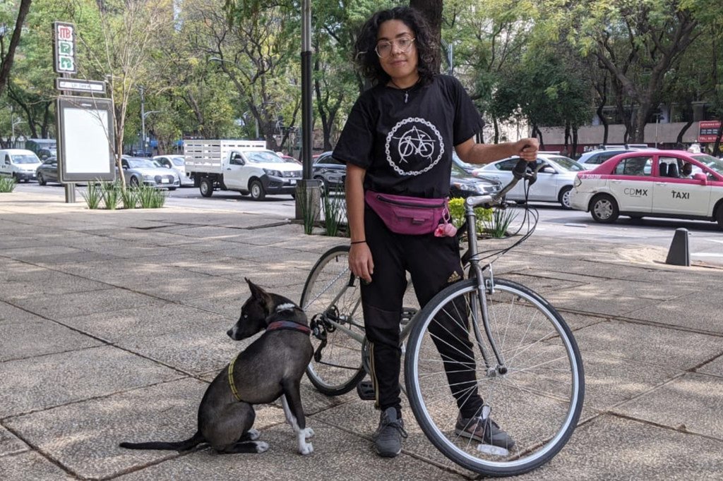 Xochitl Álvarez posa con su bicicleta y su perro en una acera de la Ciudad de México.