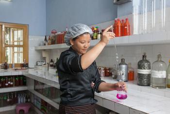 भूटान में एक महिला प्रशिक्षु कैमिस्ट, एक फल कम्पनी में परीक्षण करते हुए.