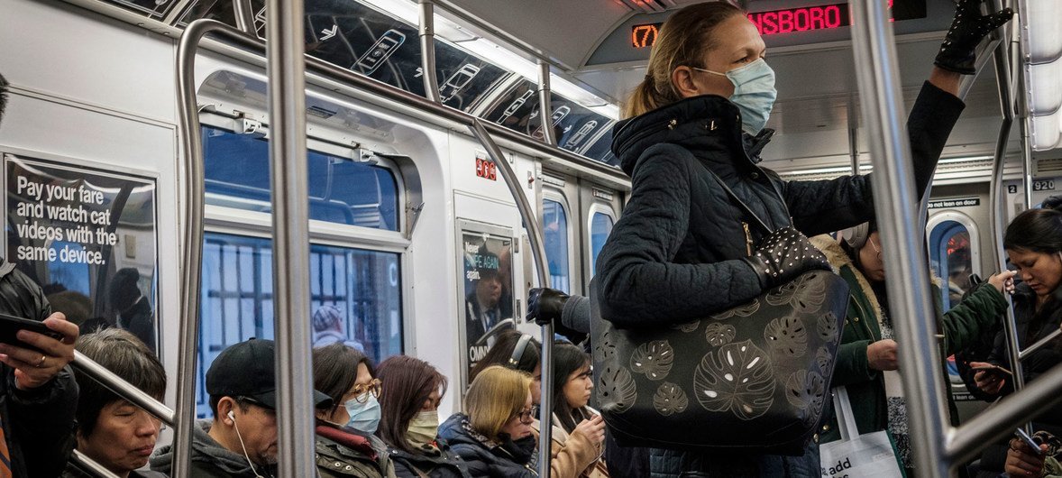न्यूयॉर्क में सबवे ट्रेन में लोग एहतियातन फ़ेस मास्क लगा कर यात्रा कर रहे हैं.