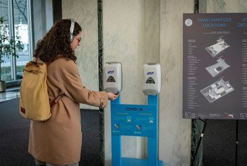 A UN staff member sanitizes her hands at UN Headquarters in New York.  