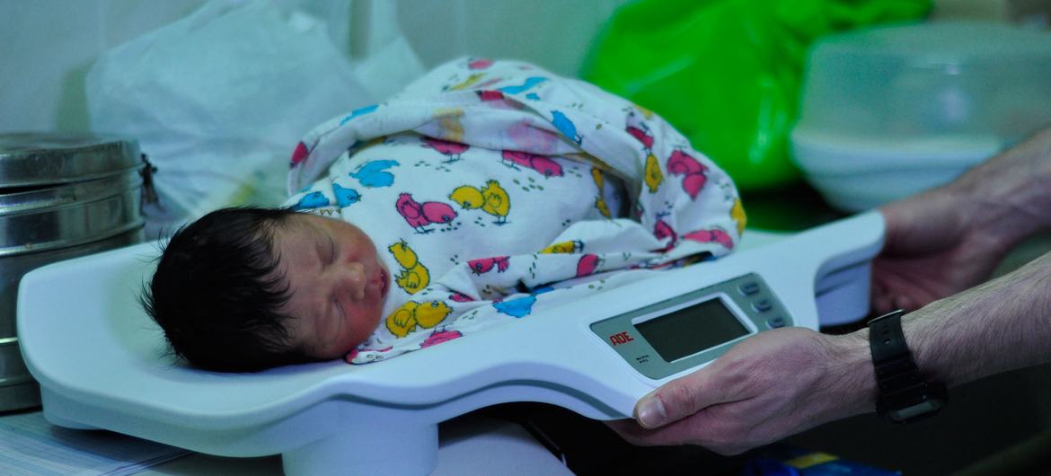 A newborn baby is weighed on a scale at a hospital in Ukraine on 7 March 2022.