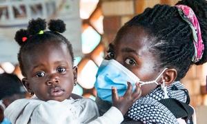 Las vacunas COVID-19 se administran en un hospital de Masaka, Uganda, donde espera esta madre con mascarilla y su bebé. 
