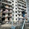 A man photographs an apartment building that was heavily damaged during escalating conflict, in Kyiv, Ukraine.