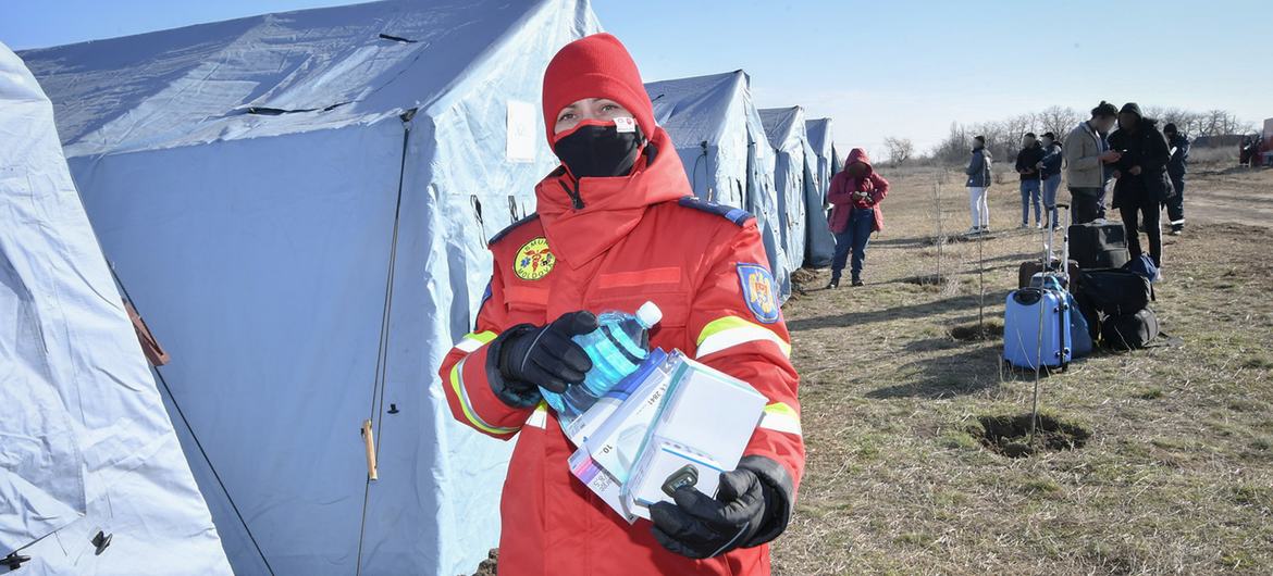 A medical worker carries COVID-19 medical supplies in a camp for Ukrainian refugees, on the border with Moldova.