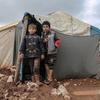 Des enfants, dont les familles ont été déplacées en raison de la guerre en Syrie, sont devant leur abri, dans le nord du pays.