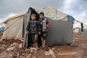 在叙利亚北部，孩子们站在他们的避难所外，他们的家人因叙利亚战争而流离失所。