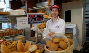 A shop worker sells bread in a bakery in Tirana, Albania