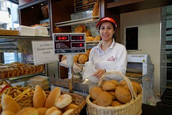 A shop worker sells bread in a bakery in Tirana, Albania