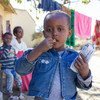 A three-year-old girl in western Tigray eats a high energy biscuit to boost her nutrition levels.