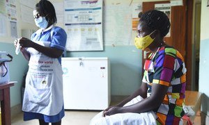 Une infirmière se prépare à administrer un vaccin contre la Covid-19 à une patiente dans un centre de santé à Kabale, en Ouganda.