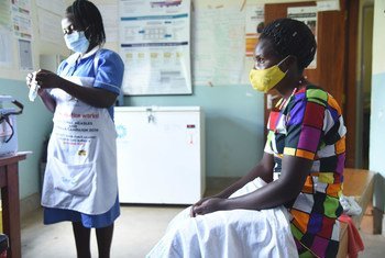 Una enfermera se prepara para administrar una vacuna del COVID-19 a un paciente en un centro de salud de Kabale en Uganda