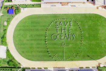 More than 200 students from half a dozen countries stand in formation to send the important message to save our oceans.