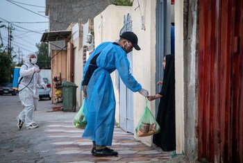伊拉克中部城市卡尔巴拉，疫情封锁期间，一名志愿者向当地家庭分发食品。