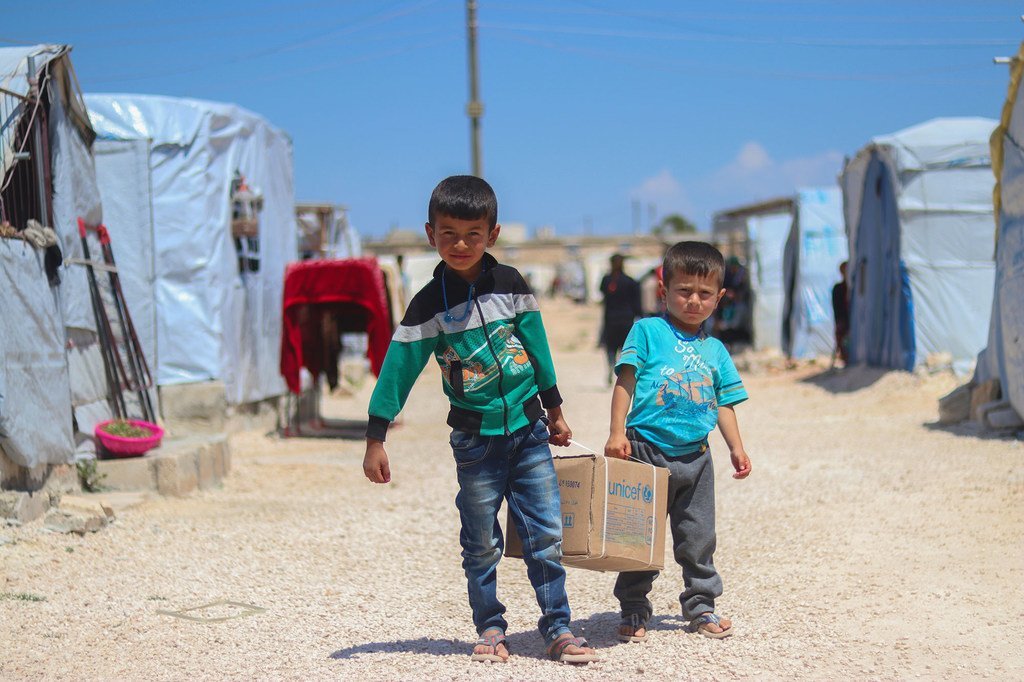 7岁的艾哈迈德兄弟(左)和5岁的萨阿德兄弟(右)带着一个卫生包回到他们在阿勒颇北部农村法芬难民营的帐篷里。
