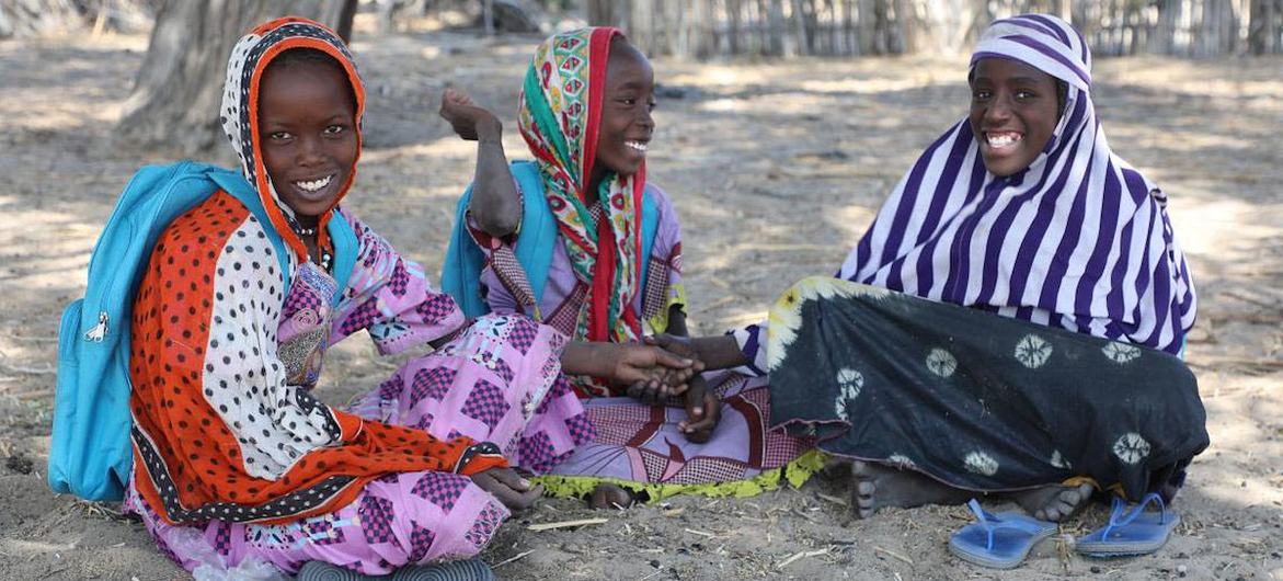 Hadjé, Achta dan Ngoleram duduk di bawah pohon di Chad, menikmati keteduhan dan udara segar dari danau.