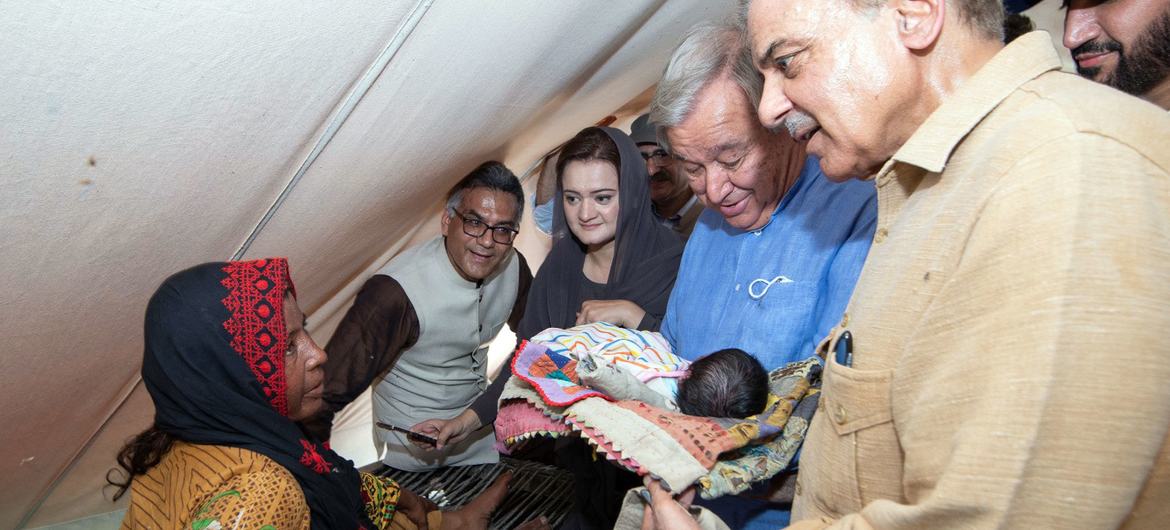 秘书长古特雷斯和巴基斯坦总理谢里夫看望了因毁灭性的洪水而流离失所的灾民。这个妇女在几个星期前刚刚生下男婴。