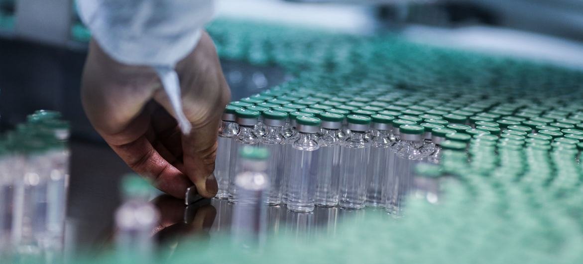 एक कर्मचारी भारत में एक COVID-19 वैक्सीन के उत्पादन लाइन पर काम करता है