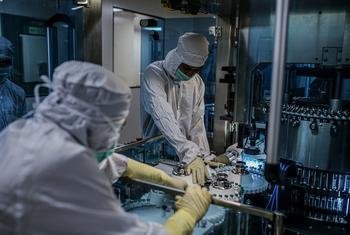 Des employés travaillent sur un site de production de vaccins contre la Covid-19 en Inde.