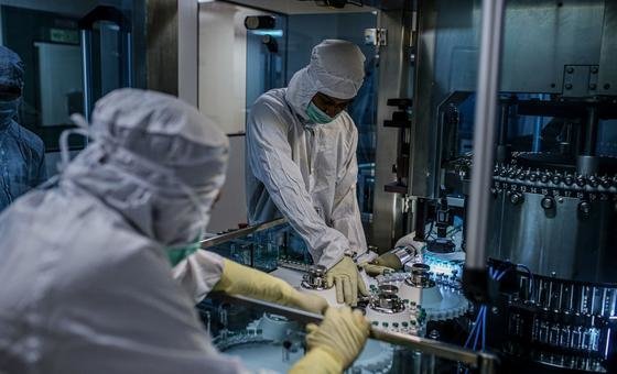 Employees work on the production line of a COVID-19 vaccine in India.